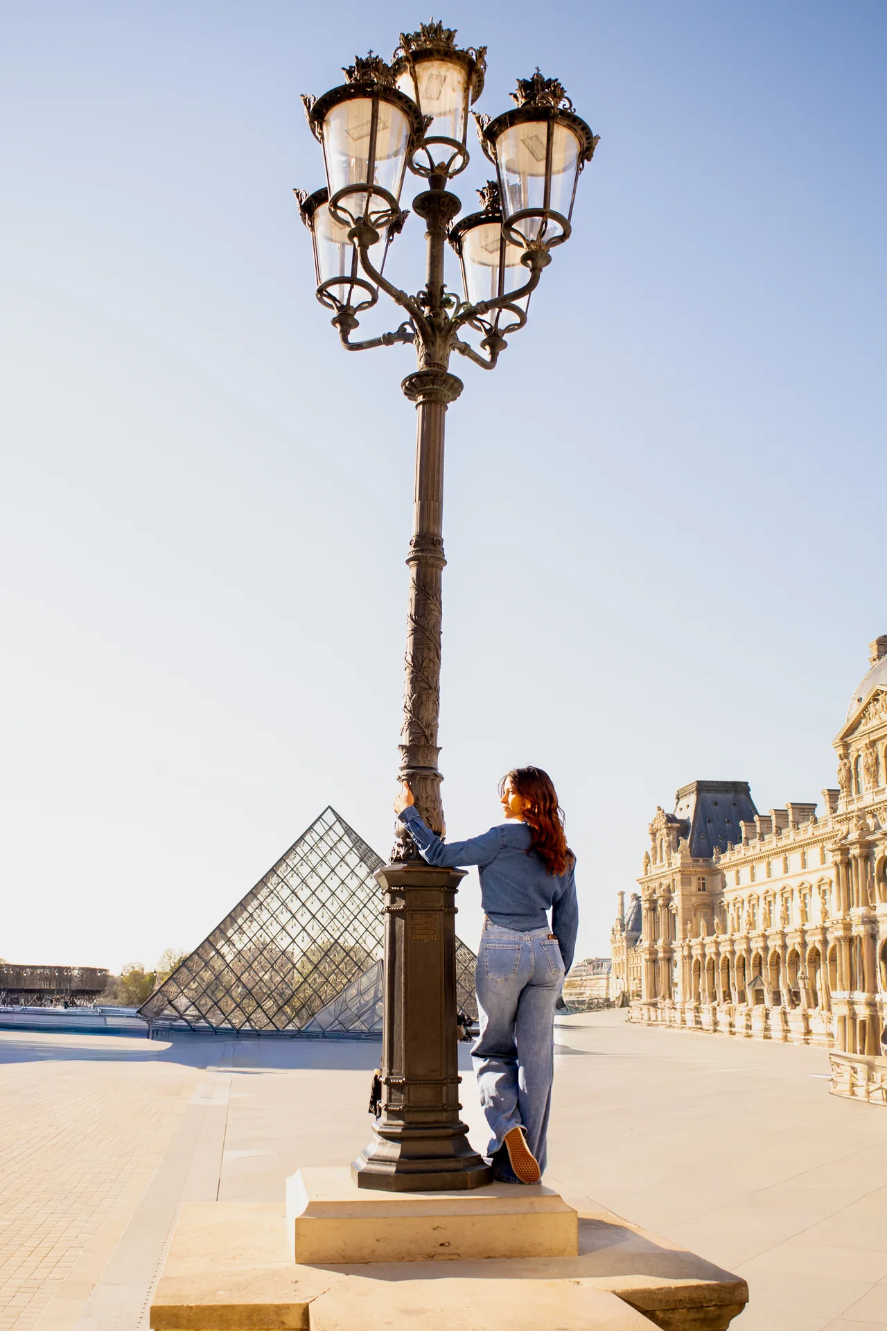 Mulher caminhando junto ao Louvre durante passeio fotográfico