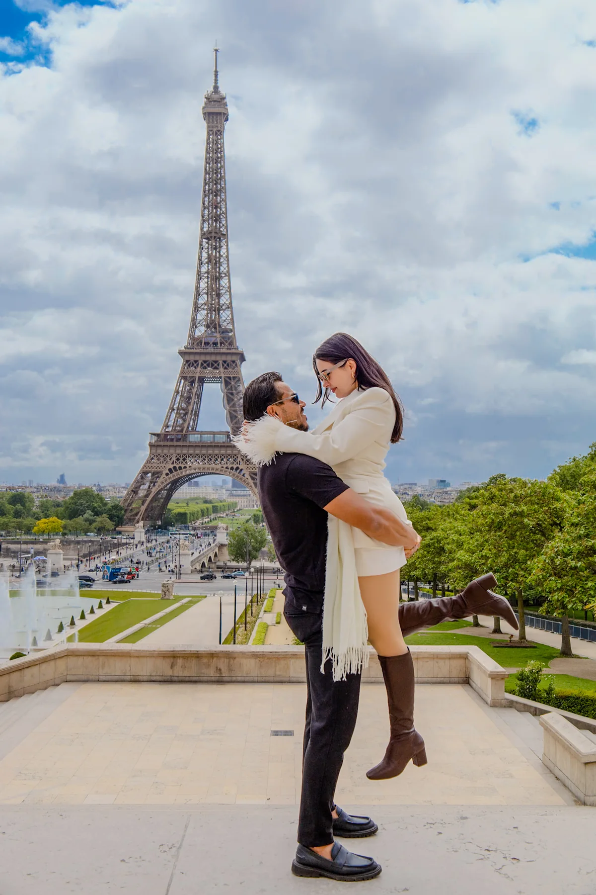 Casal em um abraço espontâneo com a Torre Eiffel ao fundo